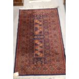 A Bokhara rug with five guls on a red ground, 39" x 25" approx, a larger similar rug, 52" x 31"