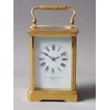 A Goldsmiths and Silversmiths brass cased carriage clock with white enamel dial and Roman