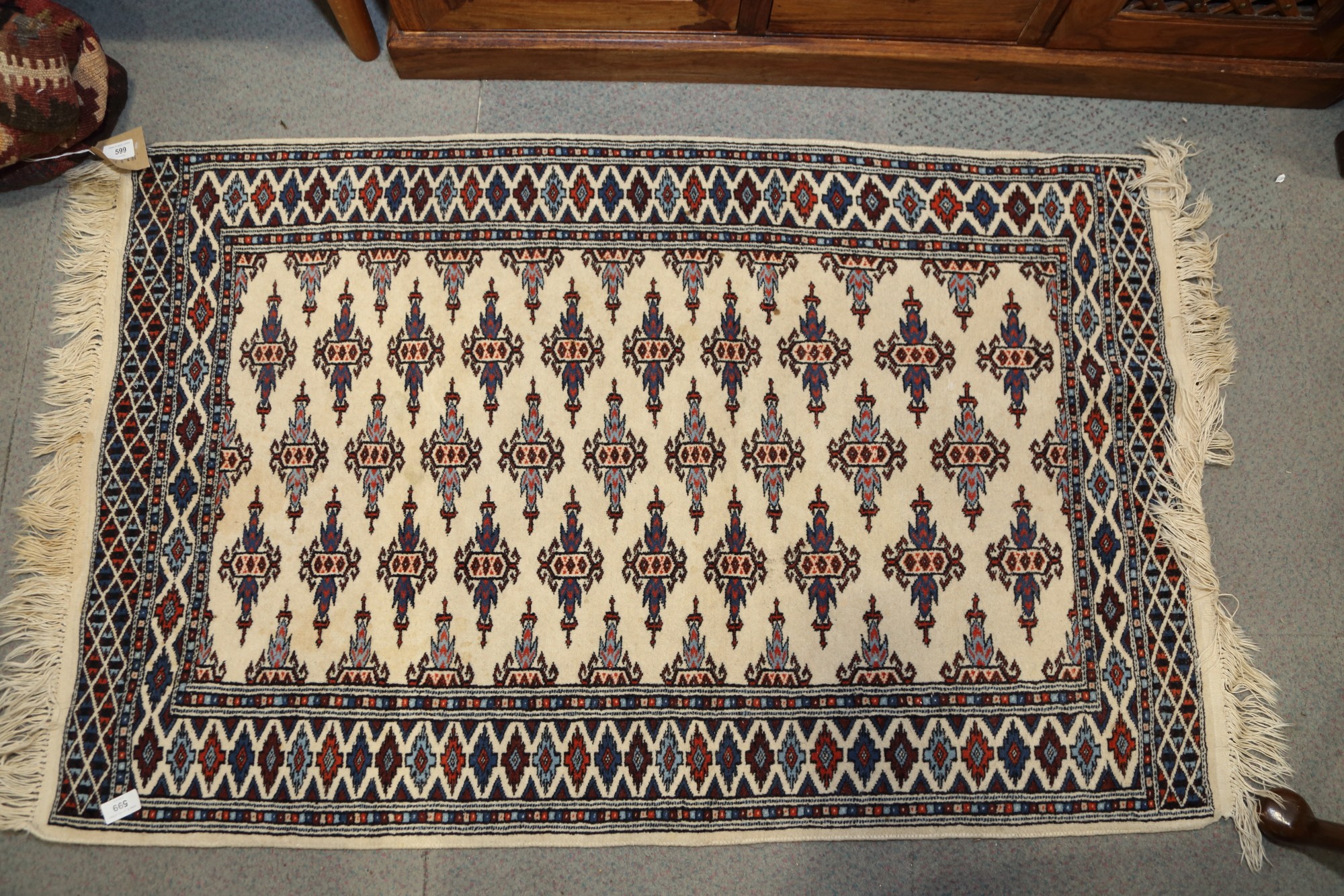 A Bokhara rug with twenty-nine hooked guls on a cream ground, 48" x 31" approx