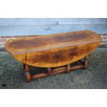 A Titchmarsh & Goodwin oval drop-leaf coffee table, on turned and stretchered supports, 48" wide x