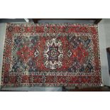 A Hamadan rug with central white medallion on a rust ground and floral borders, 50" x 78" approx