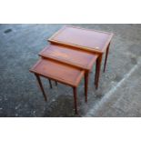 A nest of three yew occasional tables, on turned supports, 23" wide, a yew lamp table, 20" wide, and