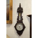 A dark oak barometer and thermometer with carved decoration, 31" high