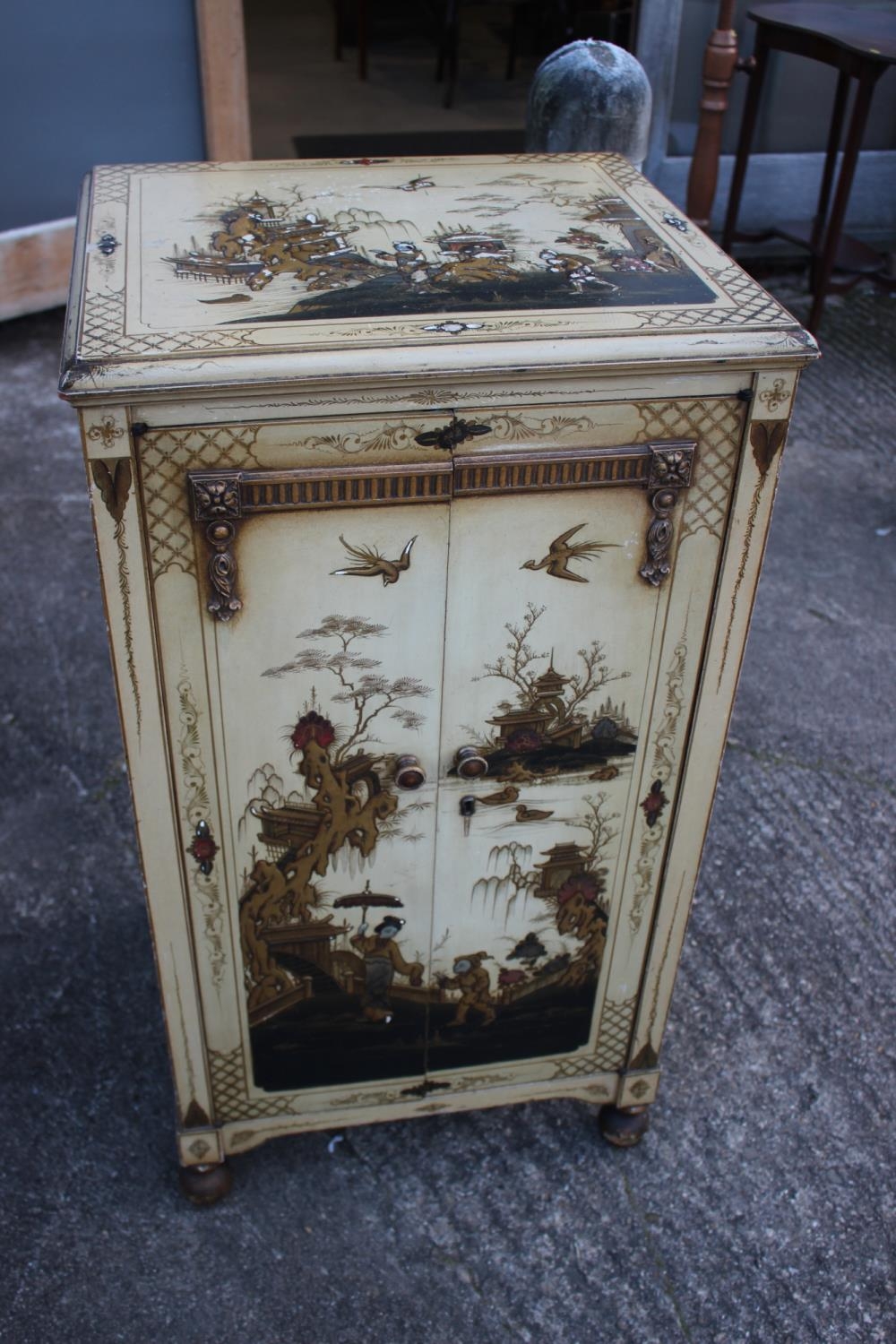 A 1930s chinoiserie white lacquered and gilt decorated record cabinet with fitted interior