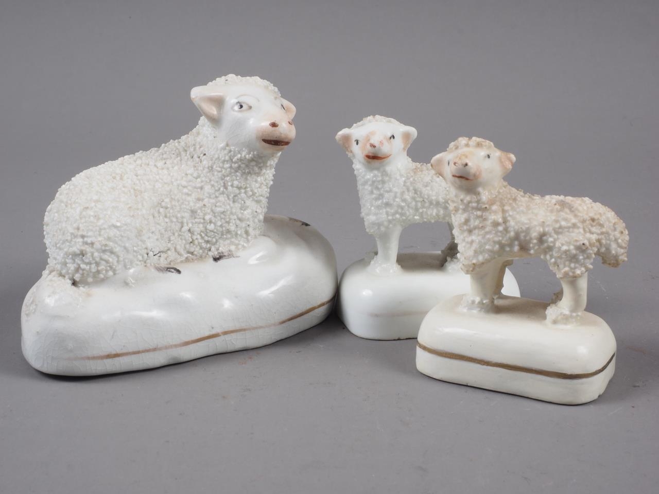 Three 19th century Staffordshire pottery figures of sheep, largest 2 1/4" high (one base restored)