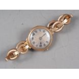 A lady's 9ct gold wristwatch with silvered dial and Roman numerals, on expanding 9ct gold