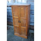 A 1920s oak cupboard enclosed two panelled doors, on block base, 24" wide x 16" deep x 50" high