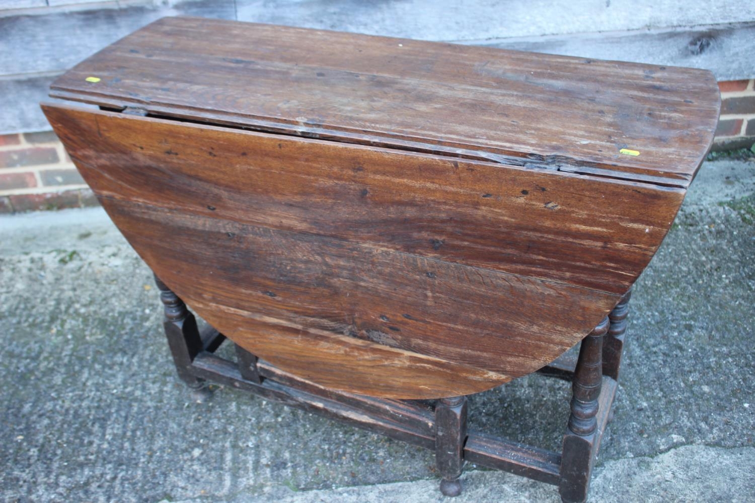 An oak oval drop leaf dining table, on turned and stretchered gate leg supports, 43" wide x 52" deep - Image 3 of 3