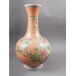 A Chinese bulbous vase with peach and flower decoration on an orange ground and six-character mark