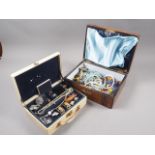 A cream jewellery box, containing a selection of costume jewellery, and a similar inlaid jewellery