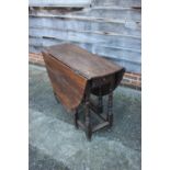 An oak oval drop leaf dining table, on turned and stretchered gate leg supports, 43" wide x 52" deep