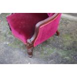 A Victorian mahogany showframe scroll arm chair, upholstered in a crimson velour  on carved and