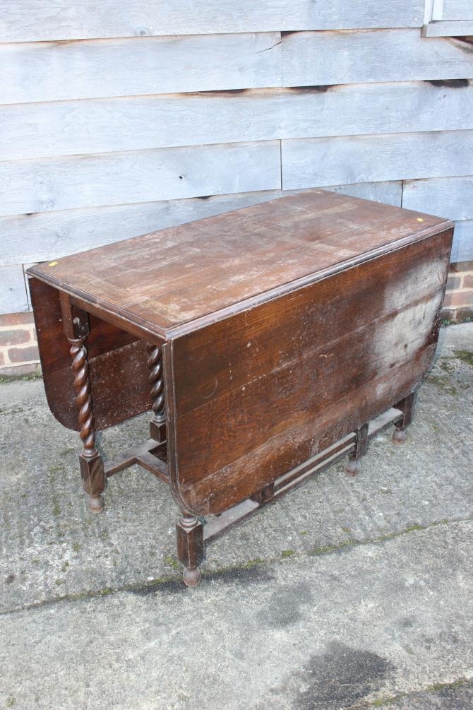 An oak drop leaf dining table, on barley twist stretchered supports, 42" wide x 60" deep x 29" high