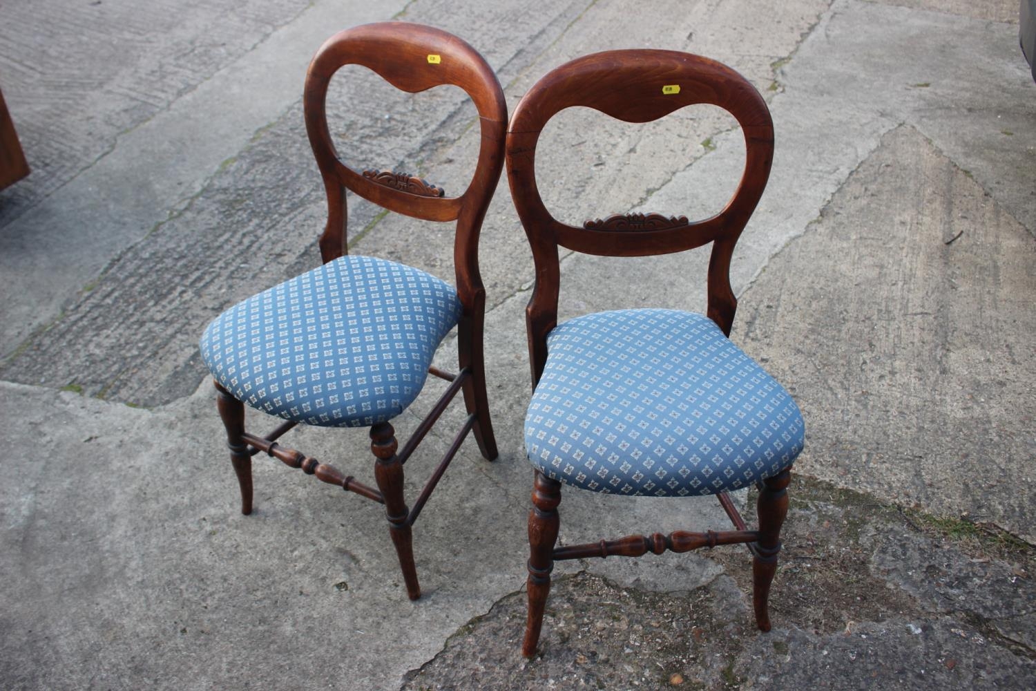 A pair of polished as walnut loopback bedroom chairs with stuffed over seats, on turned and