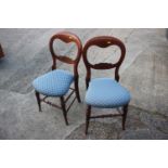 A pair of polished as walnut loopback bedroom chairs with stuffed over seats, on turned and