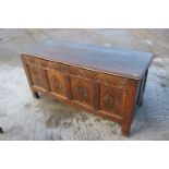 An 18th century oak plank top coffer with four panel carved front, on stile supports, 55" wide x 22"