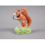 An early 19th century red squirrel with a nut, 3 1/4" high (restored)