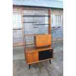 A 1950s G Plan Librenza teak room divider with ebonised shelves over cocktail cabinet and cupboard