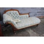 A late Victorian carved walnut showframe chaise longue, on turned and castored supports, 72" wide