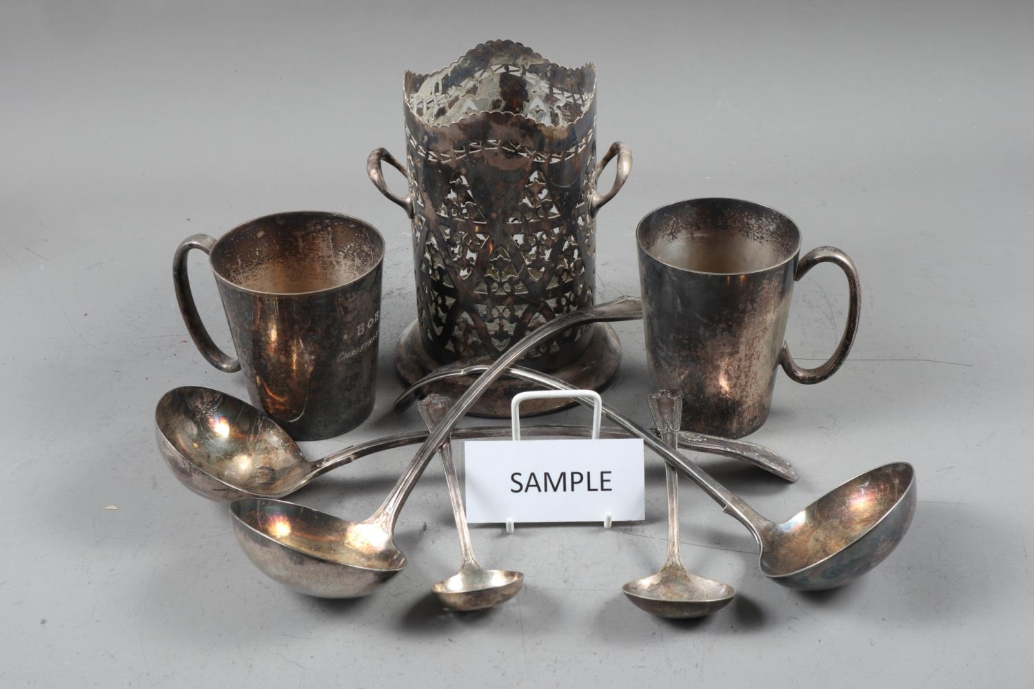 A selection of silver plated items, including mugs, a cocktail shaker, a syphon stand, loose