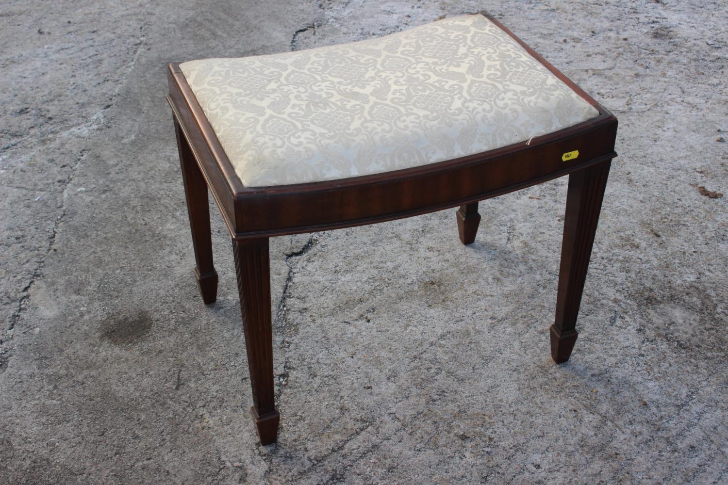 A mahogany dressing stool with dished seat, on reeded supports, 21" wide x 15 1/2" deep x 18 1/2"