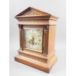 An oak cased mantel clock with carved decoration, silvered and gilt dial, and Roman numerals, on