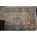A Kashan design rug with all-over floral design on a pink ground and blue ground floral border,