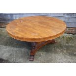 A Regency rosewood circular tilt top dining table, on triform base with scroll supports, 53" dia x