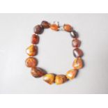 An amber "Pebble" bead necklace with white metal clasp, 90.5g, 17" long