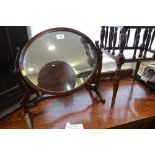 An Edwardian mahogany oval swing frame toilet mirror, on skeleton stand, 20" wide