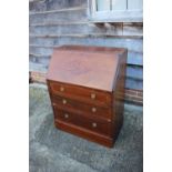 An Edwardian mahogany and satinwood banded fall front bureau with fitted interior over three long