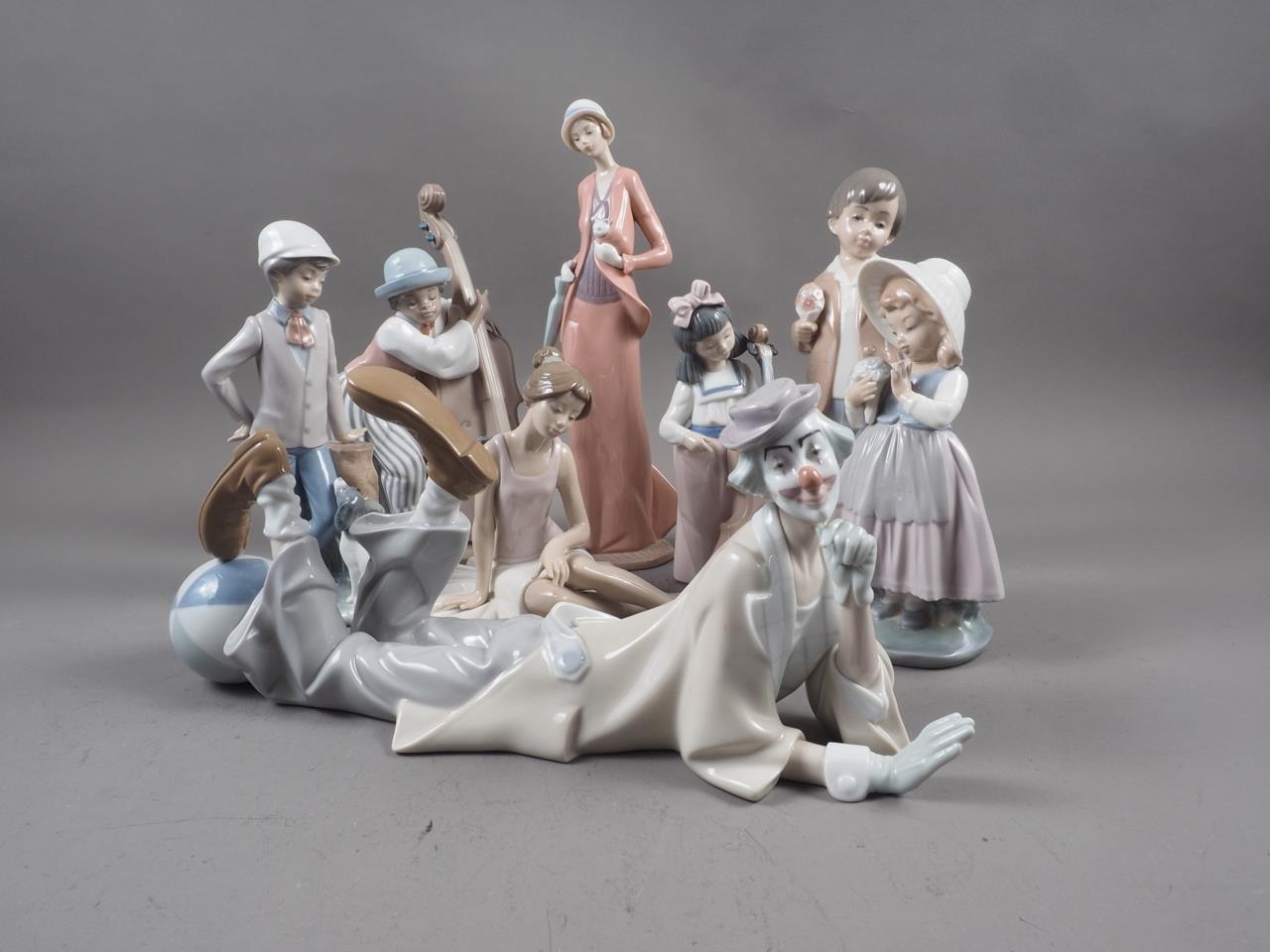 A Lladro reclining clown, 4618, a companion jazz base player and other figures, mostly boxed