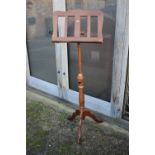 A polished as walnut music stand, on tripod splay support