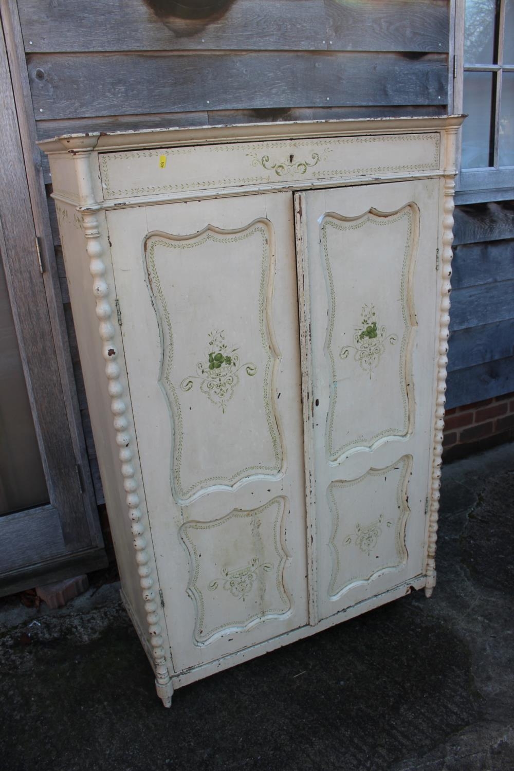 A Continental painted cupboard enclosed two doors, on turned supports, 38" wide x 18 1/2" deep x