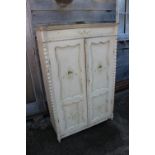 A Continental painted cupboard enclosed two doors, on turned supports, 38" wide x 18 1/2" deep x