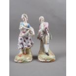 A pair of Continental porcelain figures, lady and gallant in period costume, on scroll decorated