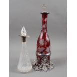 A ruby flashed and vine leaf edged decanter, on silver plated vine leaf stand with matching stopper,