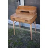 A 1960s Ercol elm and beech writing table, 437/439, with stationery compartments over one long
