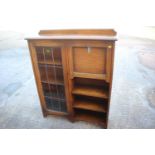 An early 20th century oak desk/book case enclosed leaded glazed door and fall front writing