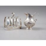 An embossed silver cream jug, 2oz troy approx, and a silver toast rack, 3.9oz troy approx