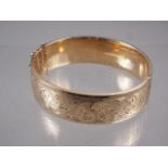 A 9ct rolled gold and engraved bangle