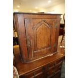 An 18th century oak wall cupboard, interior fitted shelves enclosed ogee arch top panel door, 25 1/