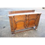 A 1930s carved oak breakfront sideboard, fitted two drawers over two doors, on cluster column