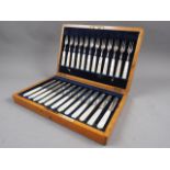 A cased set of twelve silver and mother-of-pearl fruit knives and forks