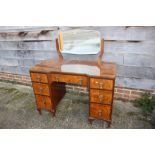A 1930s walnut inverse breakfront dressing table, fitted one long and six small drawers, on cabriole