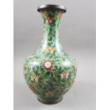 A Chinese cloisonne vase with all-over floral and precious objects decoration on a green ground,
