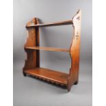 A 19th century walnut three-tier open wall shelf with Gothic pierced sides, 23" wide x 8 1/2" deep x