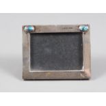 A Liberty & Co silver and turquoise cabochon mounted photo frame, 4 1/2" wide