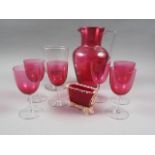 A ruby glass jug, six ruby glass wines and a rummer