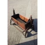 A 19th century mahogany and brass mounted swing frame cradle, on Gothic splay castored support,